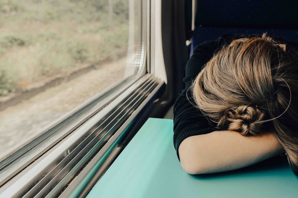 exhausted burnt out woman on train